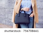 Autumn trendy outfit woman in stylish beige coat and jeans with black big bag