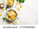 Oven baked  potato chips in bowls. Homemade crispy potato chips on white background, top view, copy space.