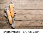Fresh Baguette Bread on wooden background. Homemade french two Baguette loafs, top view, copy space.