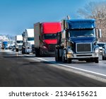 Small photo of Horizontal shot of a steady stream of trucks rolling down the interstate highway.