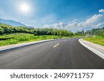 Country road and green forest with mountain natural landscape on a sunny day
