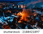 Small photo of Aerial view of steel plant at night with smokestacks and fire blazing out of the pipe. Industrial panoramic landmark with blast furnance of metallurgical production