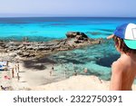 Small photo of Portrait from behind of a little kid watching the amazing "Es calo d'es mort" beach, one of the most beautiful spots in Formentera, Balearic Islands, Spain (background out of focus on purpose)