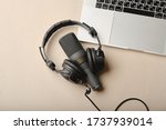 Flat lay composition with Microphone for podcasts  and black studio headphones on brown background with coffee and laptop, learning online education concept.