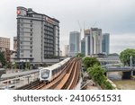 Small photo of Kuala Lumpur, Malaysia - 27 July, 2023: A train of the LRT Kelana Jaya Line is passing through the Pasar Seni LRT station. Kuala Lumpur skyline. Kuala Lumpur is a popular tourist destination of Asia.