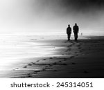 couple walking on beach. Black and white
