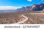 Small photo of Red Rock Canyon in Las Vegas Nevada shows a lone, remote road along the vibrant mountainside where hiking activity is common and conservationists strive to maintain a true conservancy.