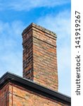 An Old Brick Chimney With Blue...