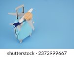 Small photo of Brain on suitcase and airplane on blue background. Brain drain concept. Copy space for text.