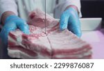 Small photo of Industrial processing of meat. A man cook cuts a piece of tenderloin in a butcher's shop on a machine with a band saw. Ribeye or marbled beef. Ribs for restaurants, slaughterhouse