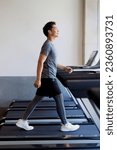 Small photo of Young Asian man walking on treadmill