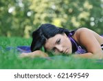 Young sad teenager lying outdoors in grass - detail