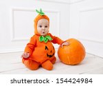 Child in pumpkin suit on white...