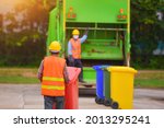Small photo of Recyclable garbage truck and the keeper in the village on during sunset.Garbage collector on the garbage truck.Selective focus