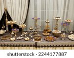 Small photo of Table with cakes, sweets, candy, buffet. Dessert table for a party goodies for the wedding banquet area. Close up candy bar.