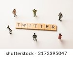 Miniature figures businessman : meeting on twitter word by wooden block words on white paper background, in concept of social media, communication and corporation