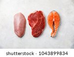 Raw food turkey breast, beef meat and Salmon oily fish steak on white textured background