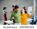 Small photo of Businesspeople celebration in the office. A happy, tipsy colleagues hugging, holding champagne, and celebrating success in the office.