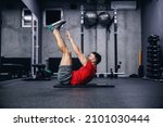 Small photo of Fitness routine and weight loss, sports life. Man correctly performs demanding core exercises on the pathos of the modern gym and sports center concept. Individual training and achieving fitness goals