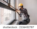 A repairman fixing windows in new apartment.