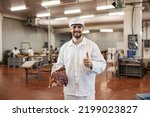 A Satisfied Butcher Holds A...