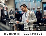 Small photo of An elegant man is shopping with credit card in boutique.