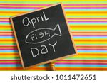 Small photo of Chalkboard with phrase "April fish day" on color background