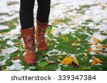 Female legs and fallen autumn leaves on grass background