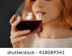 Young woman with glass of red wine closeup