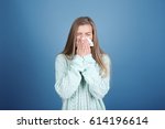 Young woman blowing nose on tissue against color background