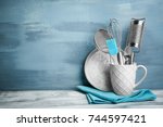 Kitchen utensils in cup on table against wall