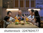three generation asian family gathering at home celebrating holiday having a toast
