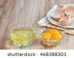 Separated egg white and yolks into two bowls and broken egg shells  are at background 