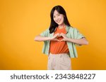 Small photo of healthcare and wellness with an 30s Asian woman, wearing a green shirt. Witness her heart hand gesture on her chest against a yellow background, truly embracing the embodiment of body wellness.