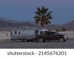 Small photo of Tecopa, California, USA - March 24, 2022: image of an Airstream Trailer and pickup truck shown in the Mojave Desert at daybreak.