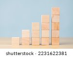 Wooden blocks increasing graph bar, infographic diagram, chart made of wooden blocks over front on blue background
