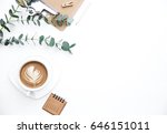 Flay lay, Top view office table desk. Feminine desk workspace frame with green leaves eucalyptus, clipboard and coffee  on white background.  ideas, notes or plan writing concept
