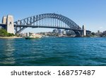 Dramatic widescreen image of the city of Sydney including the Rocks, Bridge and Dawes Point Park and Sydney Ferries ferry boat making its way to Circular Quay in the harbour
