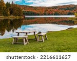 Rustic wooden table and chairs by Silver Lake in Barnard Vermont during the fall season