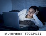 young beautiful hispanic internet addict woman in pajamas on bed at home bedroom asleep while working with laptop computer late at night in dark room light just exhausted falling sleep 
