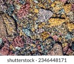 Small photo of Close-up of multi-colored rocks in a creek near Logan Pass in Glacier National Park, Montana, USA. The flowing water sparks shiny specular highlights.