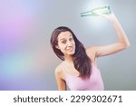 Small photo of Girl with green bottle celebrates, appears slightly tipsy. Young woman in pink tank top looks like she's having fun and also a bit drunk. The bottle is possibly beer. She's cheerful and there are part