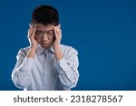 Small photo of Young Asian man shows suffering, sadness. Is it a severe headache, a breakdown, or need for mental help? Maybe an economic or emotional loss? His expression signals negative, evident dismay