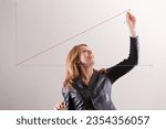 Small photo of Radiating positivity, a woman sketches a red diagonal on Cartesian axes, either in the air or on a transparent board. Her enthusiasm for science and the successful method she's showcasing is palpable