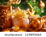 Image of luxury New Year gifts, different present boxes under Christmas tree in holiday eve, Christmastime celebration, home decorated with festive shiny balls, magic x-mas night