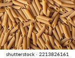 Uncooked whole grain pasta. The raw penne pasta. Top view.