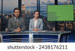 Small photo of Two presenters broadcasting news at mockup television media channel closeup. Happy anchors hosting newscast standing chromakey tv studio. Charismatic couple newscasters talking collaborating in air