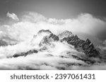 Snow covered peaks of the Sesto Dolomites in clouds, mountains of the Alps, black and white photo, South Tyrol, Italy, Europe