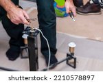 Small photo of an elec trician with pliers fixing the lamp, indoor shot