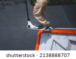 Small photo of Skate park view with kids on a kick scooter doing tricks and stunts, boys in a skate park riding bmx bike and skate, playing and enjoying summer on new ramp, teenagers skateboarders and bmx riders